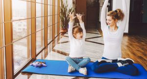 Madre e hija practicando yoga en casa